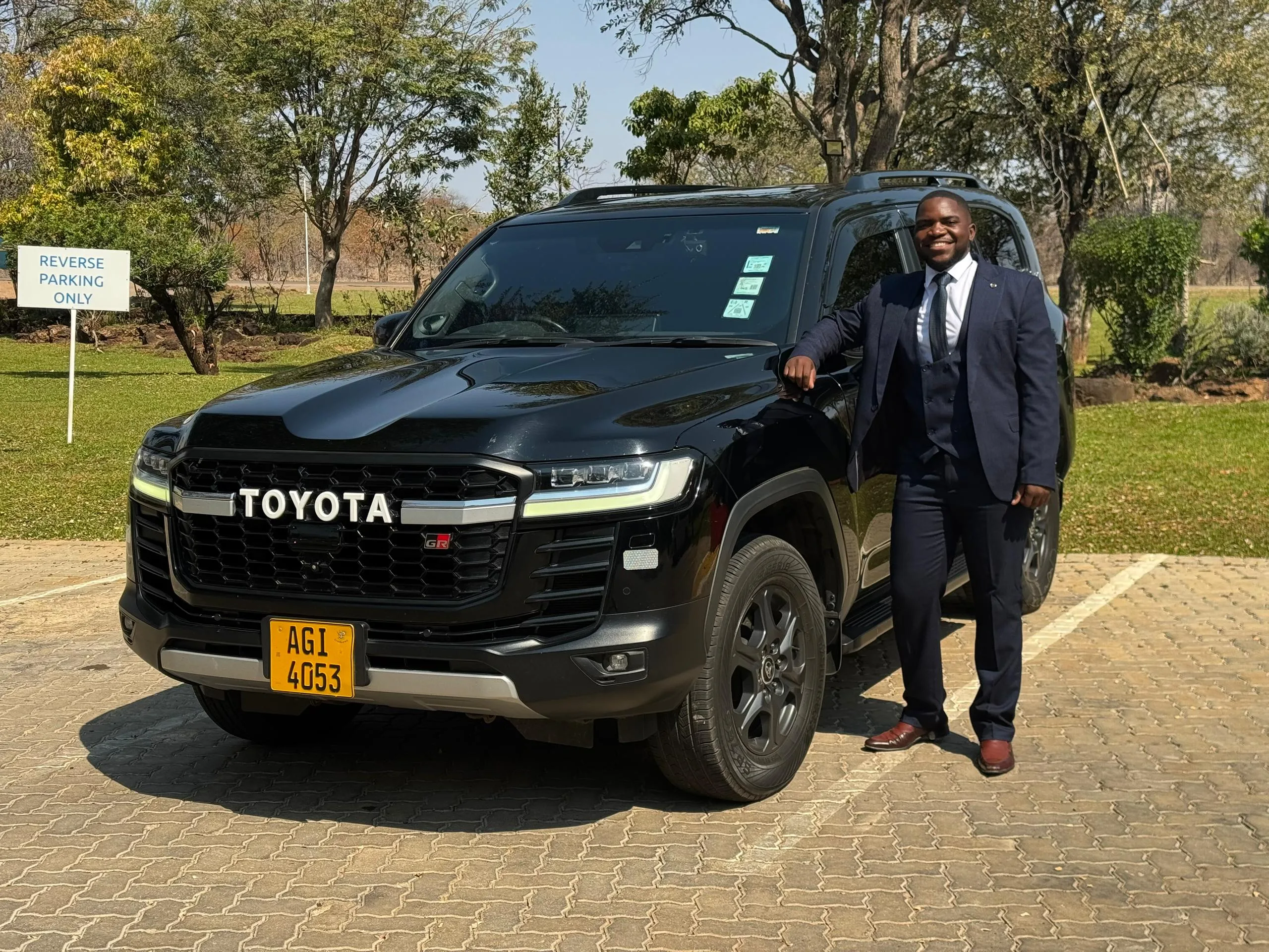 Professional chauffeur standing next to a Land Cruiser 300 GR Sport